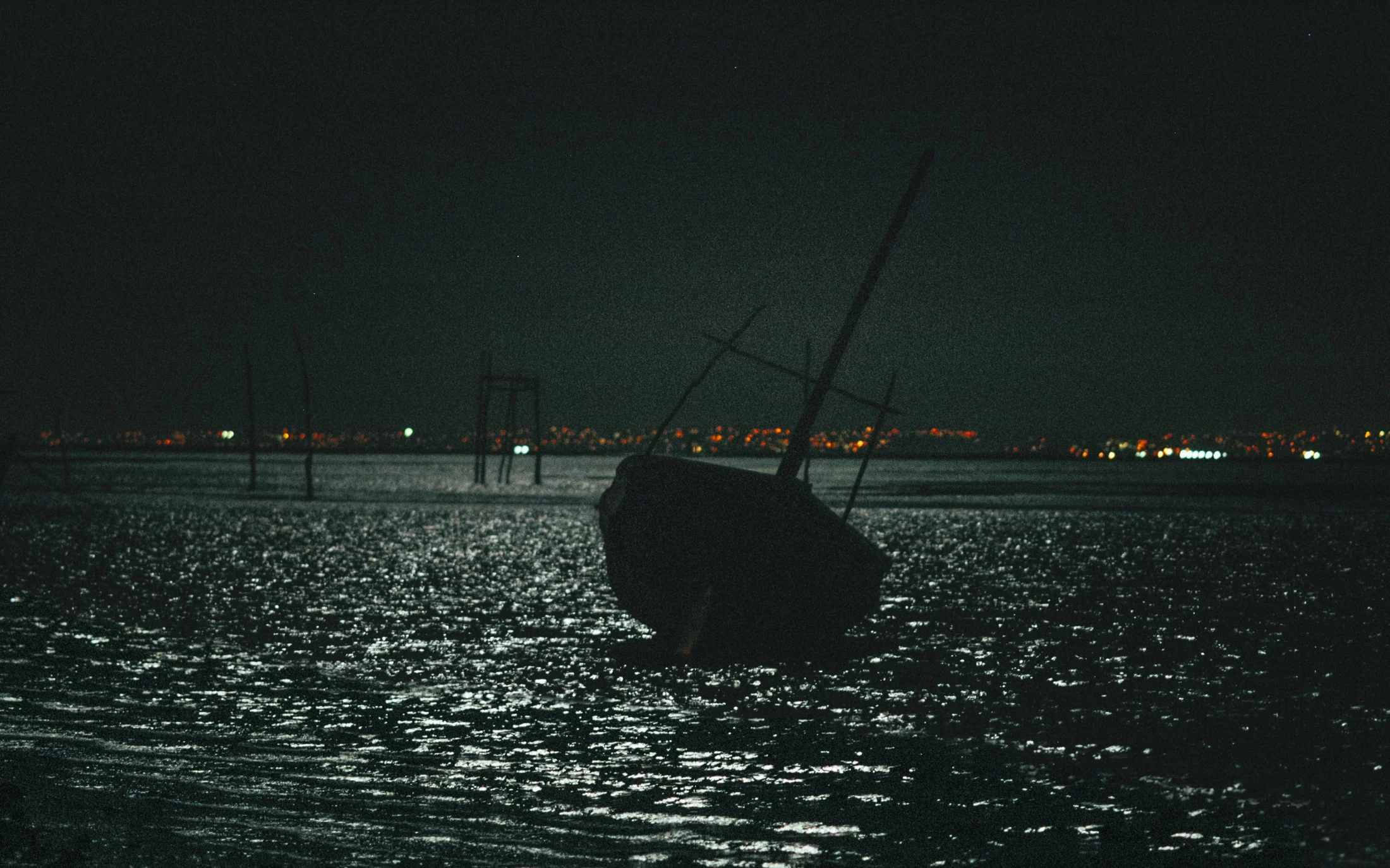 A boat resting on dark water in the moonlight, Penha, 2004